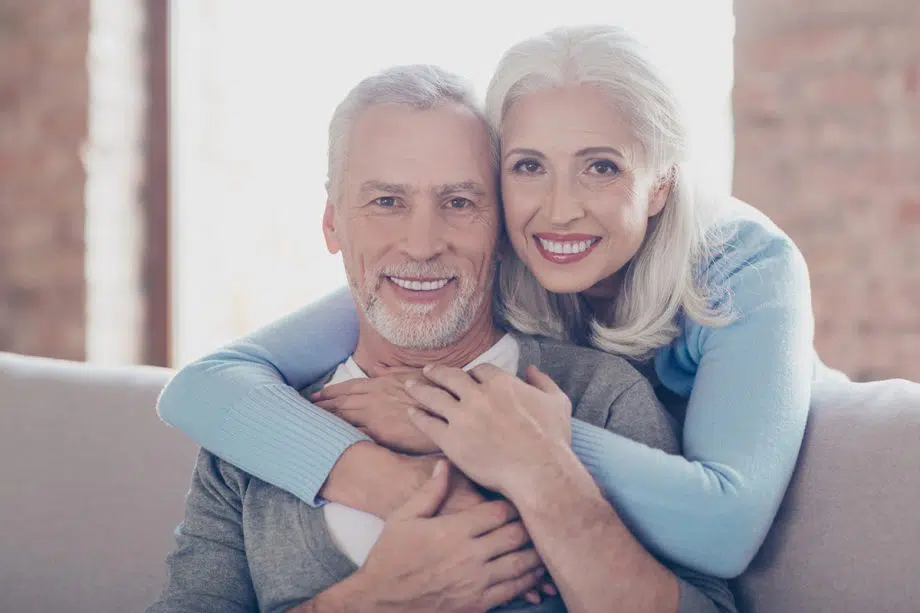 mature couple hugs on couch