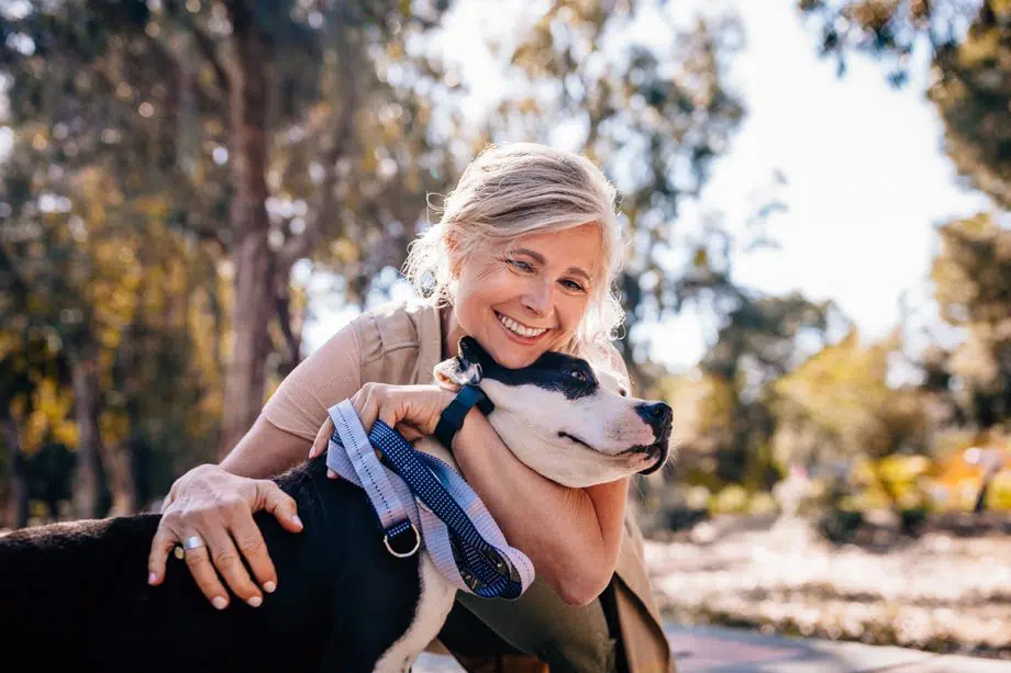 woman hugs dog outside