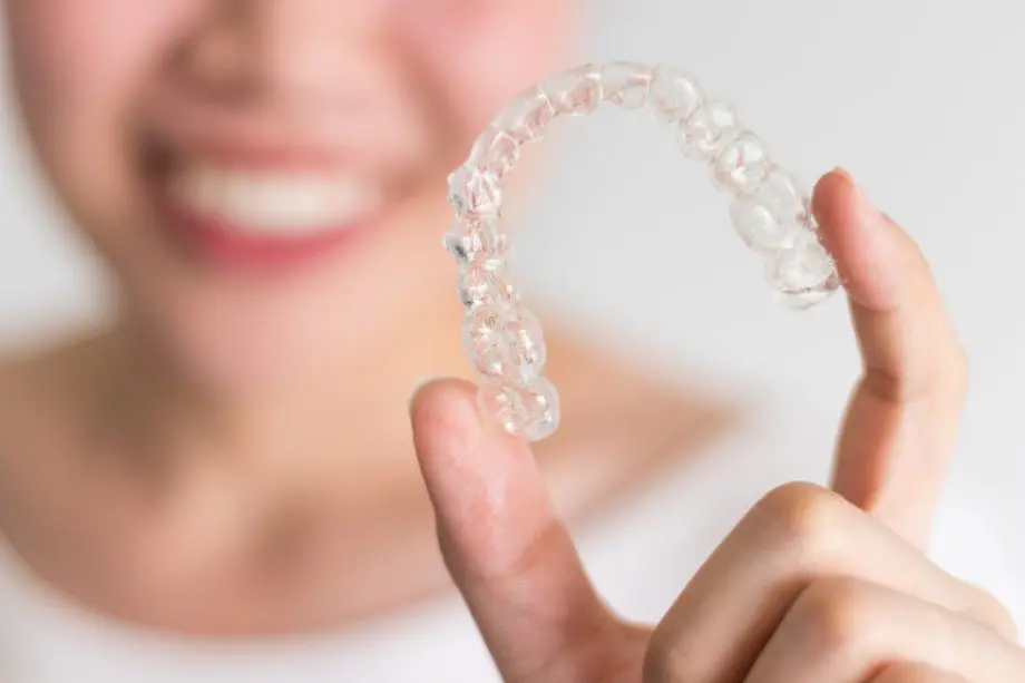 woman holding invisalign